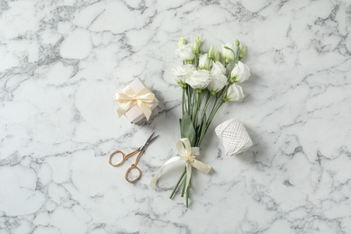 Photo of Flat lay composition with scissors and flowers on white marble background