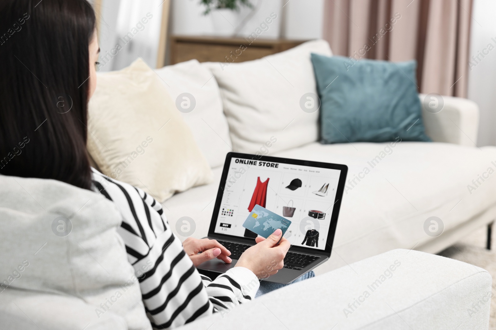 Photo of Woman with credit card using laptop for shopping online indoors, closeup