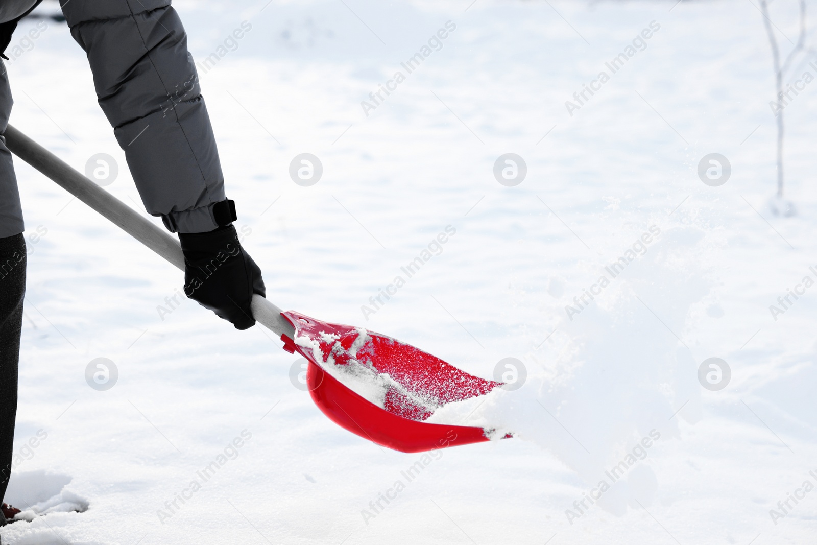 Photo of Man removing snow with shovel outdoors, closeup