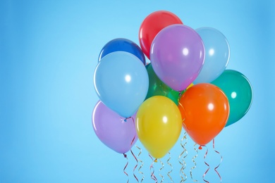 Photo of Bunch of bright balloons on color background. Space for text