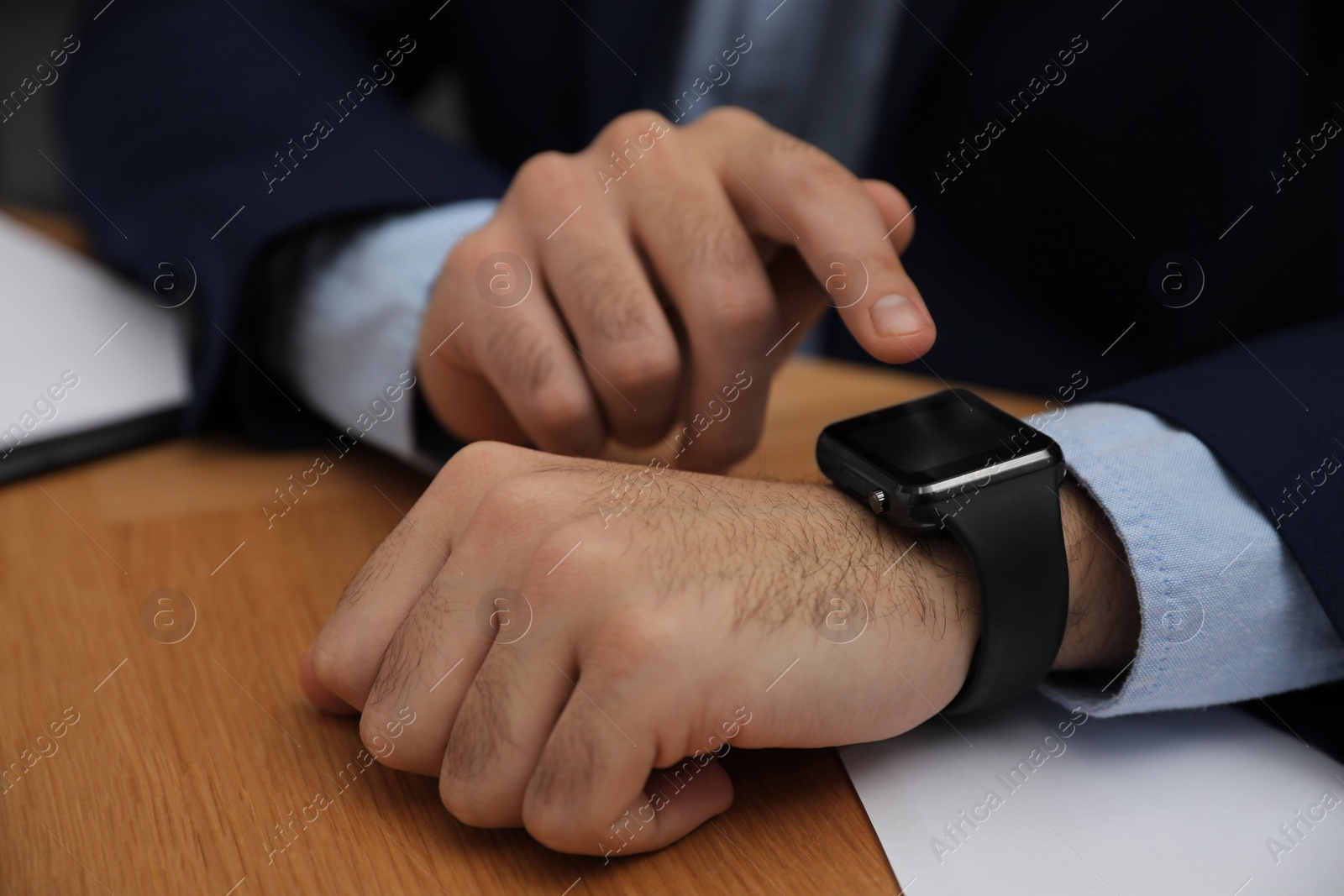 Photo of Businessman with smart watch at desk in office, closeup