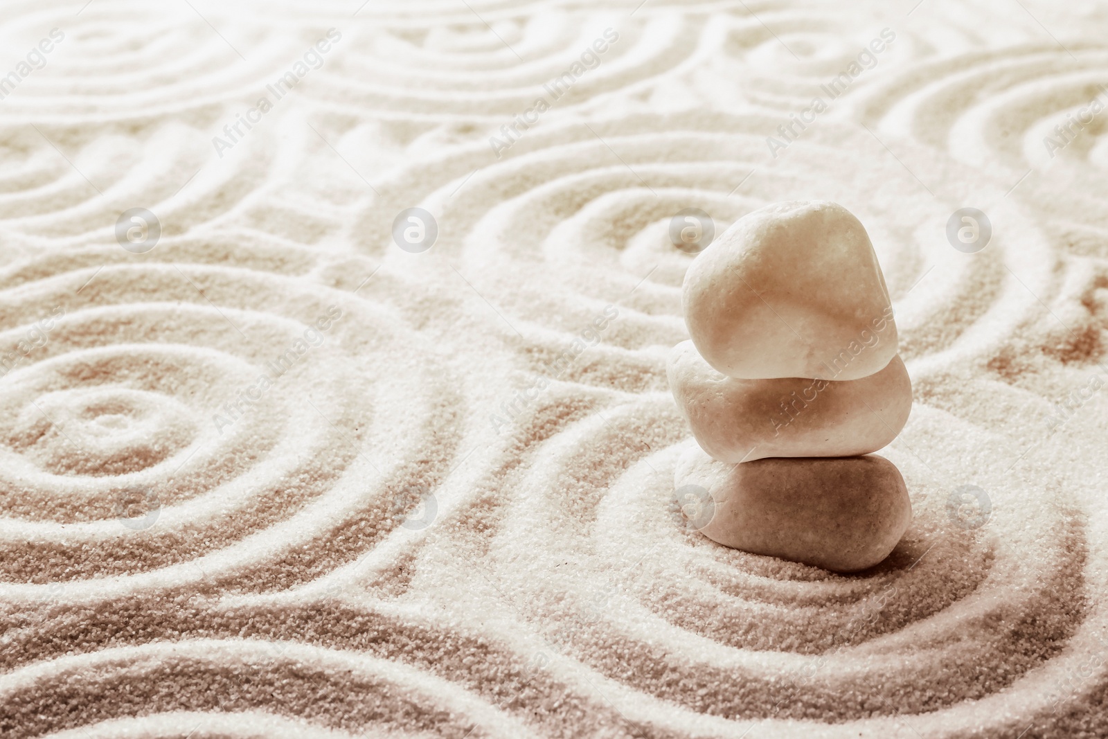 Image of Stack of white stones on sand with pattern, space for text. Zen, meditation, harmony