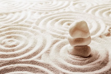 Stack of white stones on sand with pattern, space for text. Zen, meditation, harmony