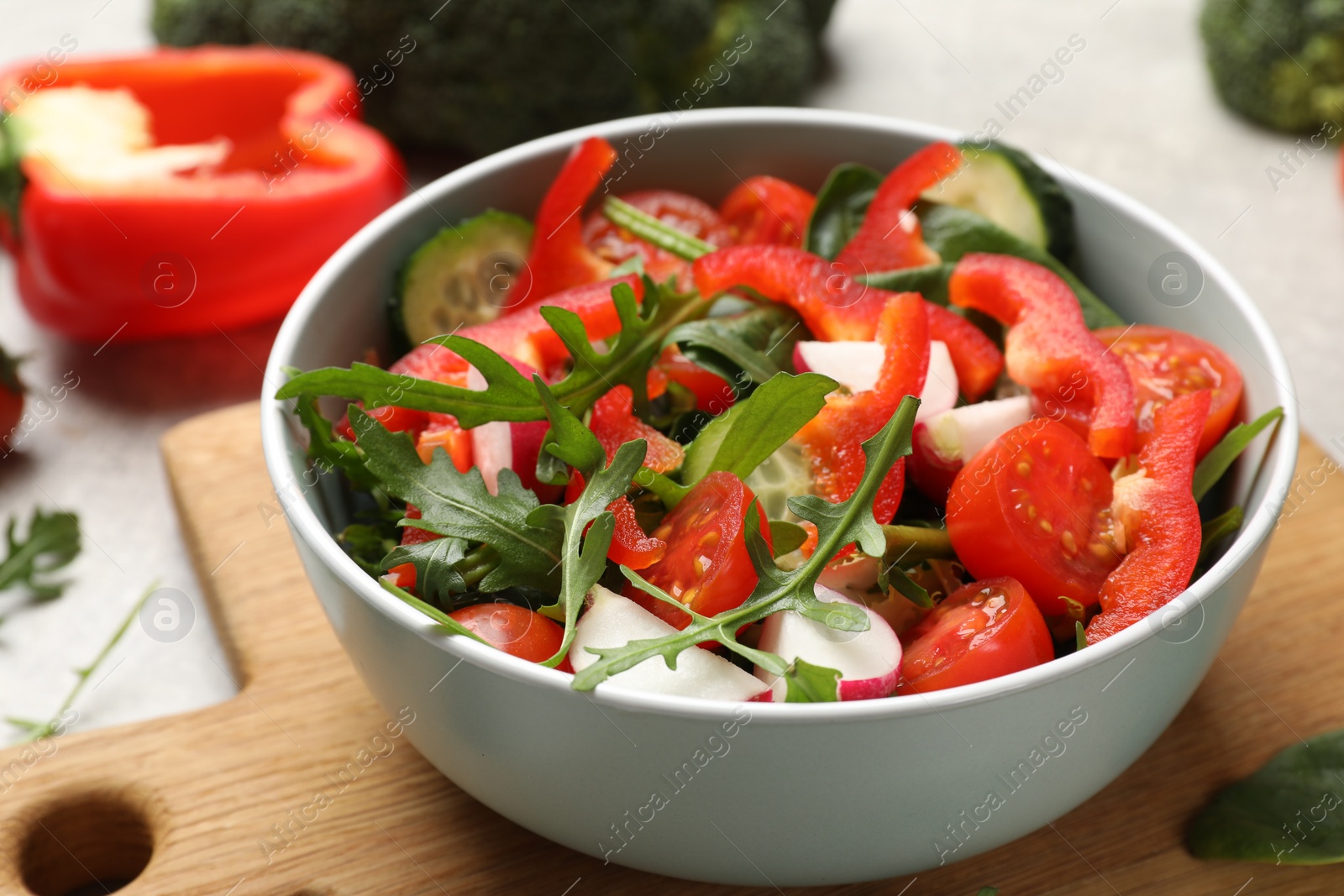 Photo of Tasty fresh vegetarian salad on light grey table, closeup