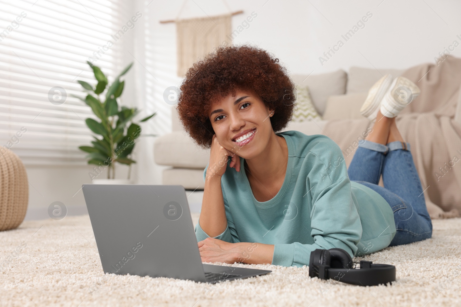 Photo of Beautiful young woman using laptop in room