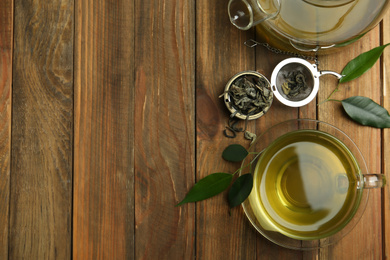 Flat lay composition with cup of green tea on wooden table. Space for text