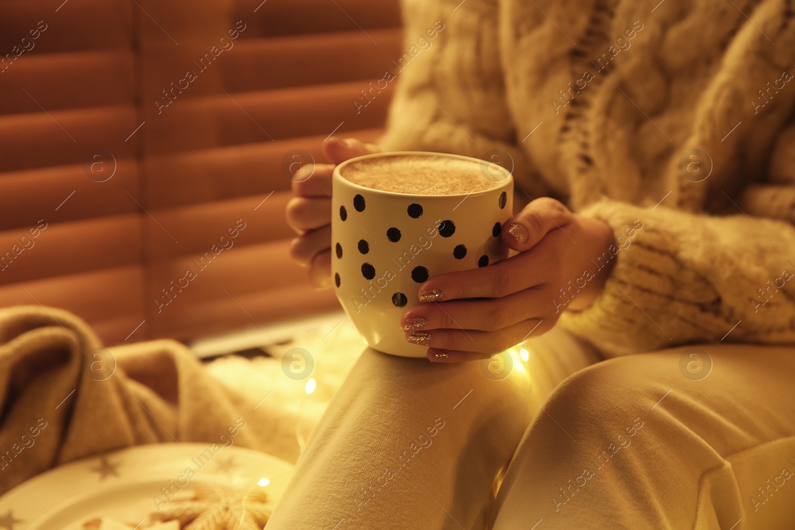 Photo of Woman with cup of hot drink at home, closeup