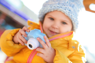 Photo of Cute little photographer outdoors, focus on hands with camera