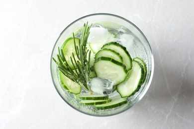 Photo of Glass of fresh cucumber water on light background, top view