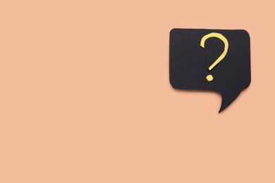 Paper speech bubble with question mark on beige background, top view. Space for text