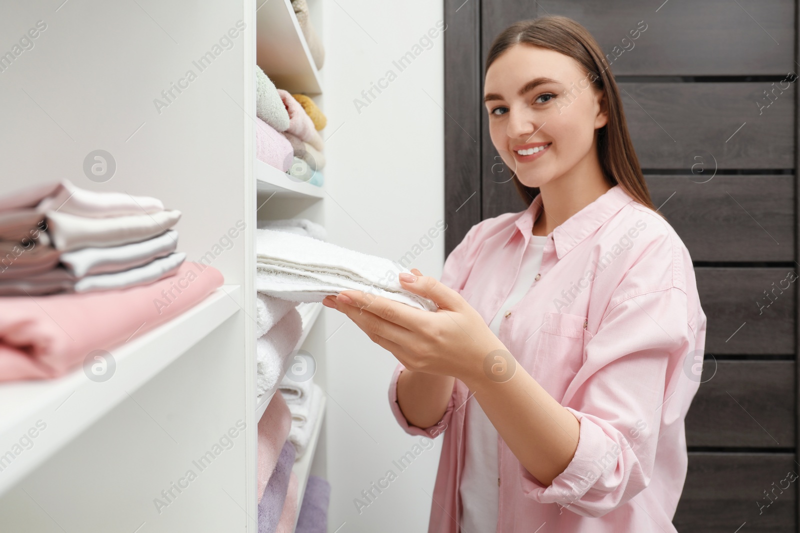 Photo of Happy customer choosing bed linens in shop