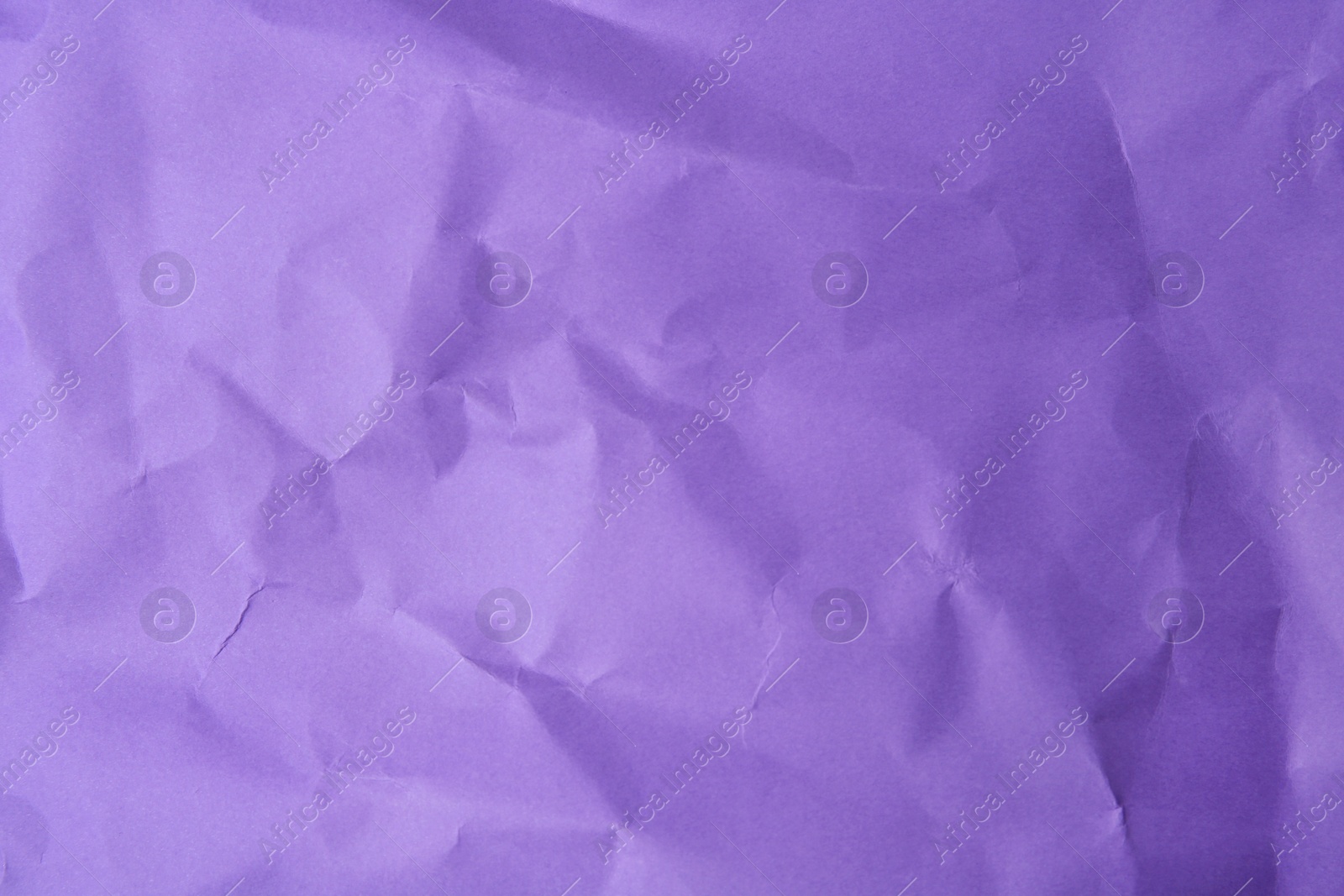 Photo of Sheet of crumpled violet paper as background, top view