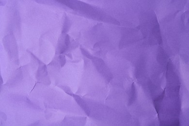 Sheet of crumpled violet paper as background, top view