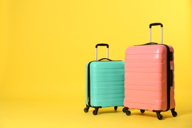 Photo of Stylish suitcases on color background. Space for text