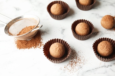 Tasty raw chocolate truffles on marble background