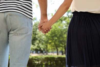 Lovely couple walking together in park on sunny day, closeup