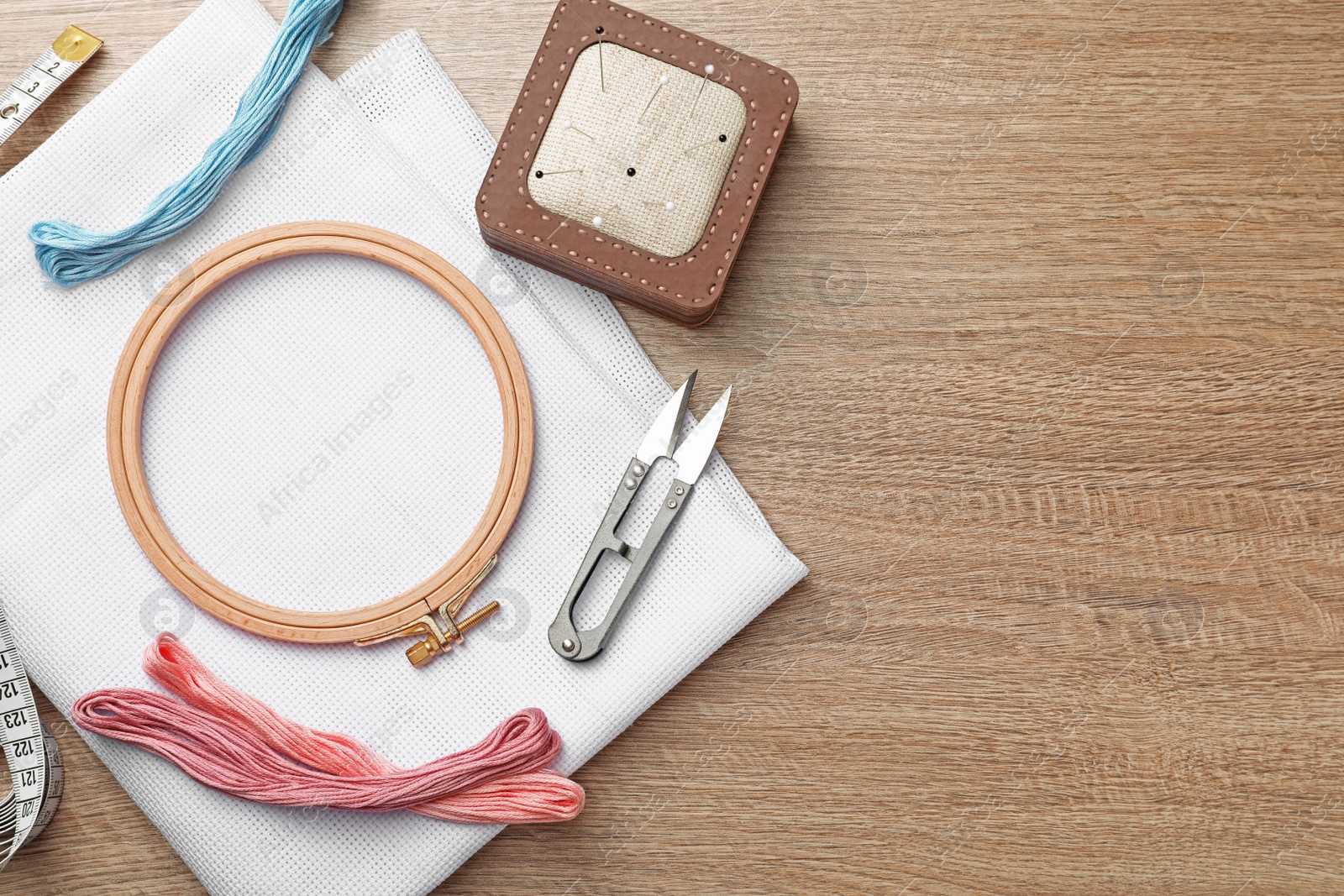 Photo of Set of embroidery equipment on wooden table, flat lay. Space for text