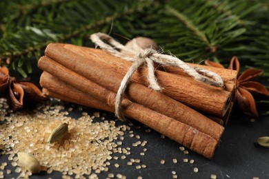 Different spices and fir branches on table, closeup