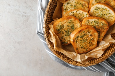 Photo of Slices of toasted bread with garlic and herbs on grey table, top view