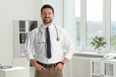 Photo of Portrait of smiling doctor with stethoscope in hospital. Space for text