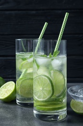 Photo of Glasses of natural lemonade with lime on table