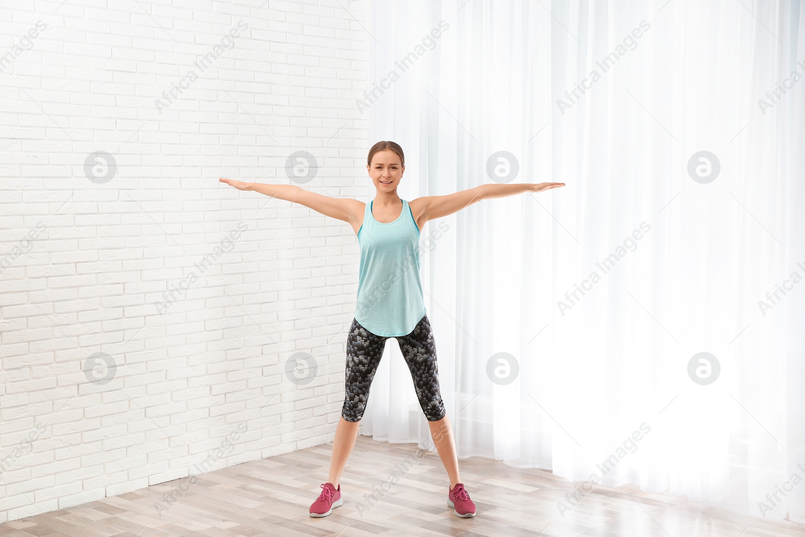 Photo of Young woman doing fitness exercises at home