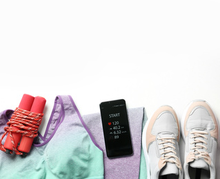 Photo of Smartphone with fitness app and sport accessories on white background, flat lay. Space for text