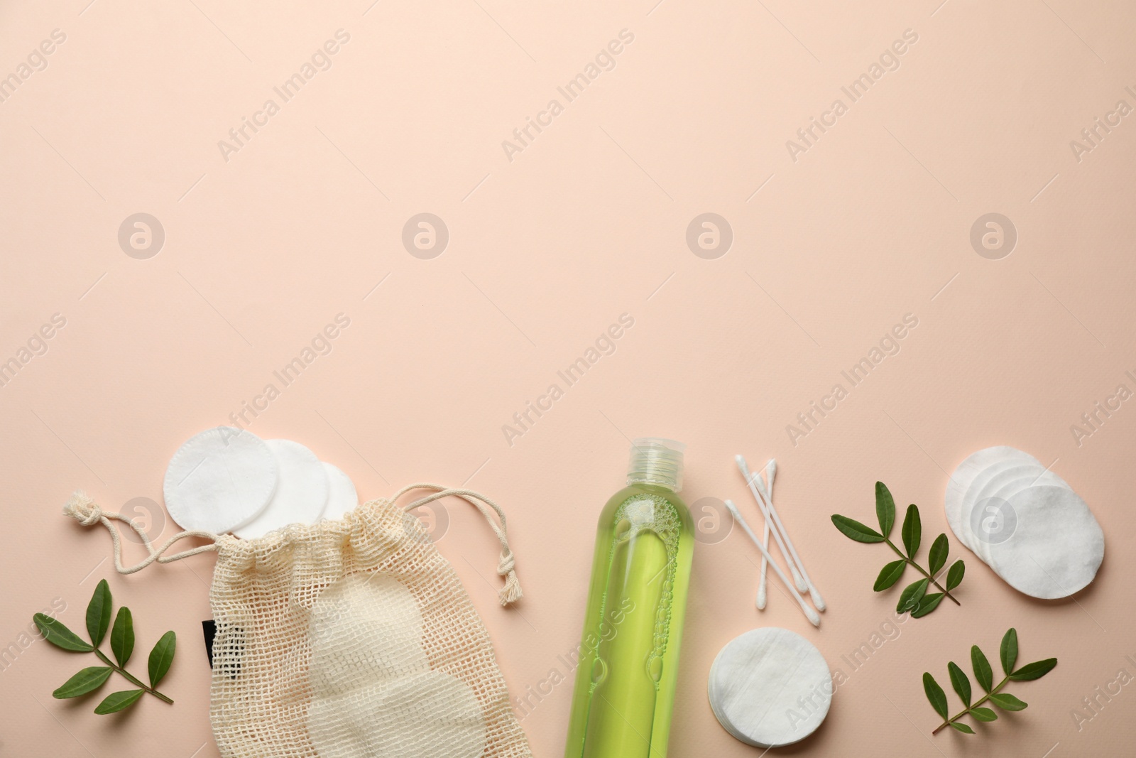 Photo of Cotton pads, swabs and makeup removal product on beige background, flat lay. Space for text