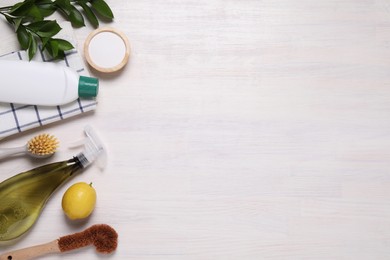 Flat lay composition with different cleaning supplies on light wooden background, space for text