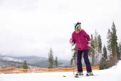 Female skier on slope at resort, space for text. Winter vacation