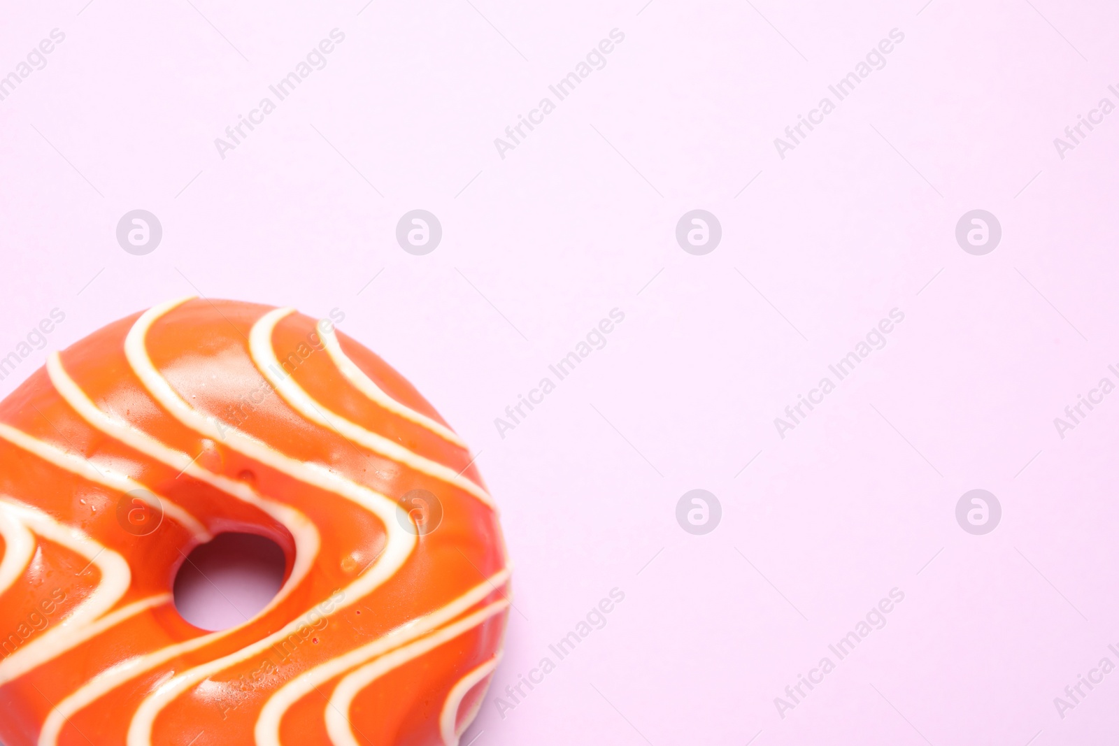 Photo of Delicious glazed donut on lilac background, top view. Space for text