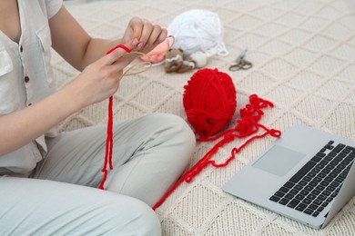 Photo of Woman learning to knit with online course at home, closeup. Handicraft hobby