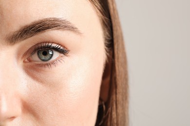 Closeup photo of woman with beautiful eyes on light background. Space for text