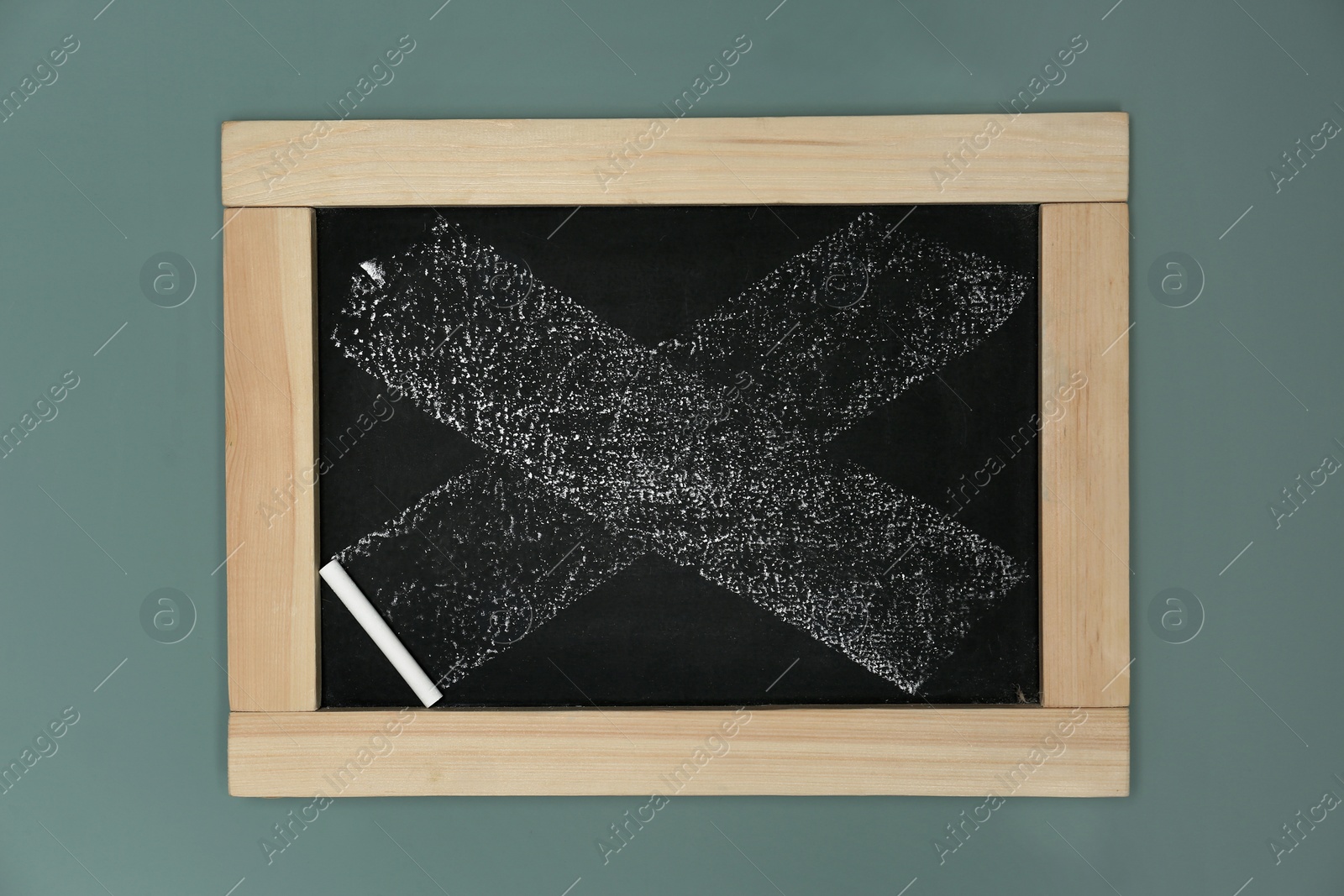 Photo of Small dirty chalkboard hanging on color wall