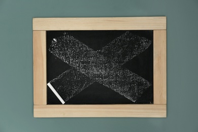 Photo of Small dirty chalkboard hanging on color wall