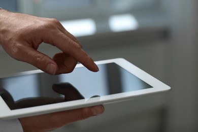 Closeup view of man using new tablet indoors