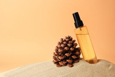 Photo of Bottle with serum and cone on sand against orange background, space for text. Cosmetic product