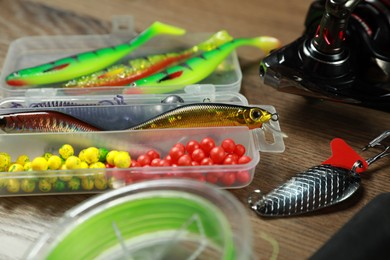 Photo of Different fishing baits on wooden background, closeup
