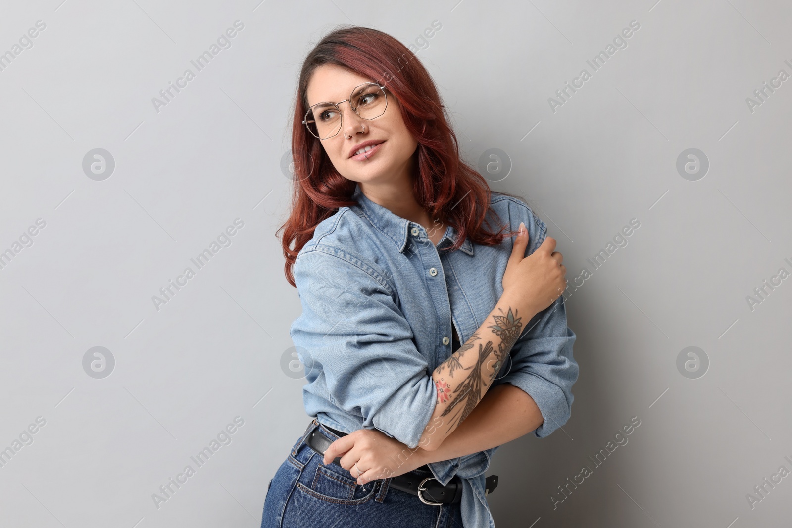 Photo of Portrait of beautiful tattooed woman on gray background