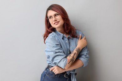 Portrait of beautiful tattooed woman on gray background