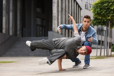 Photo of Men dancing hip hop outdoors, low angle view