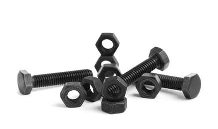 Photo of Different black metal bolts and nuts on white background