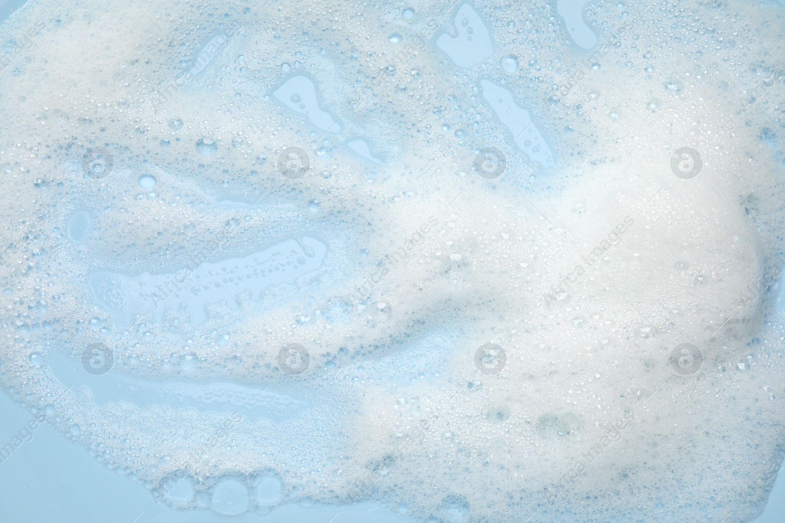 Photo of White washing foam on light blue background, top view