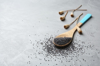 Photo of Spoon with poppy seeds on grey background