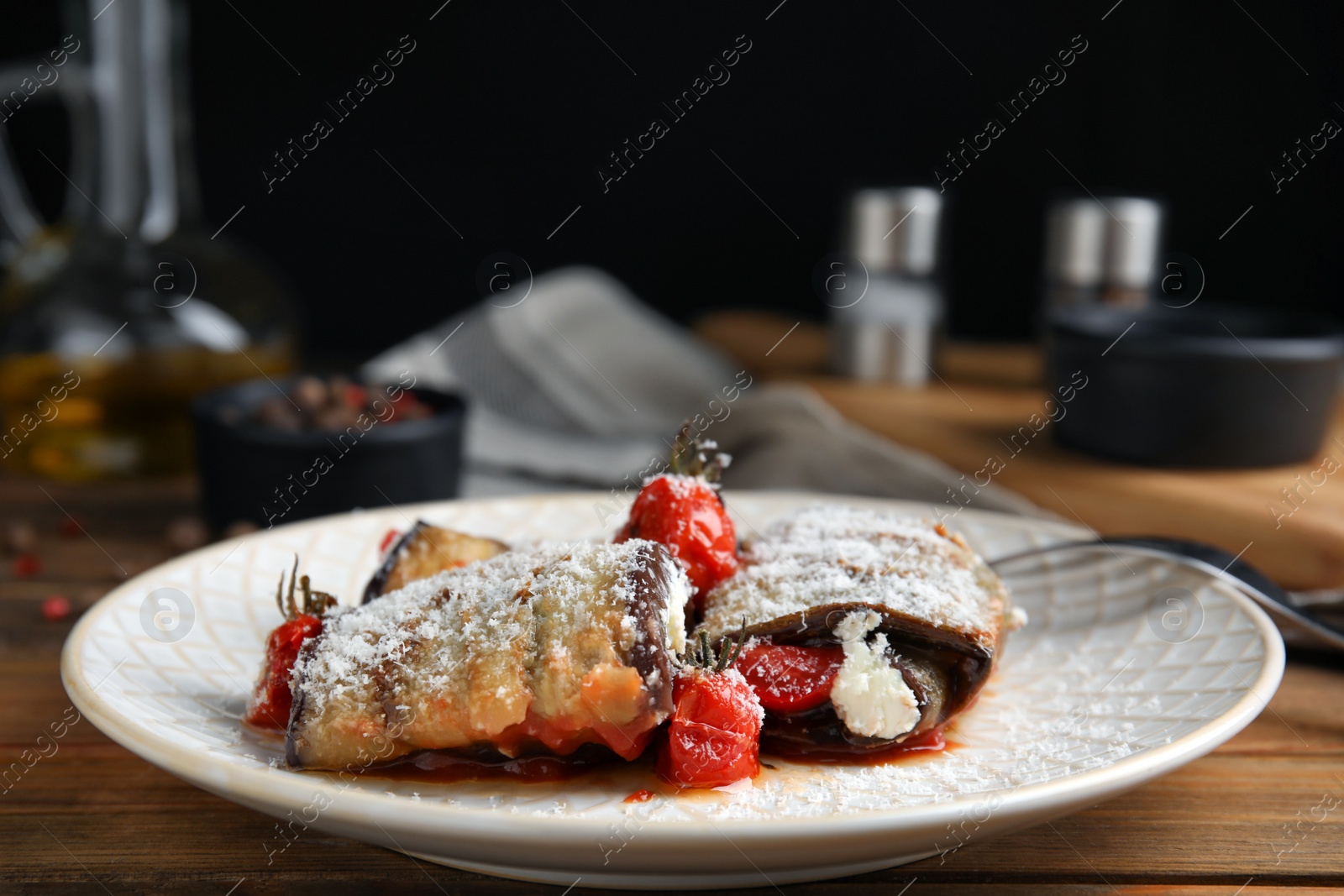 Photo of Delicious baked eggplant rolls served on wooden table, closeup