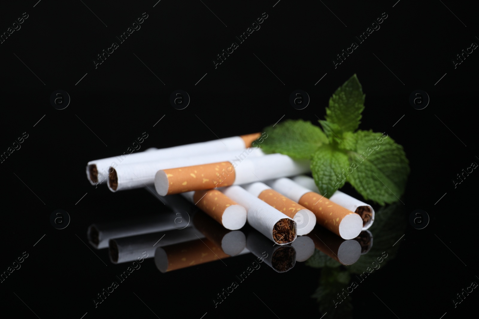 Photo of Menthol cigarettes and mint on black background