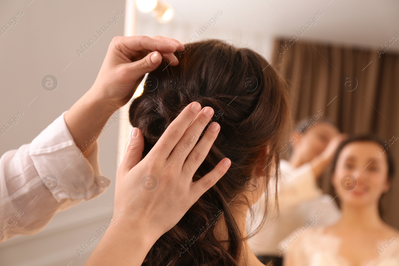 Photo of Stylist working with client in salon, making hairstyle