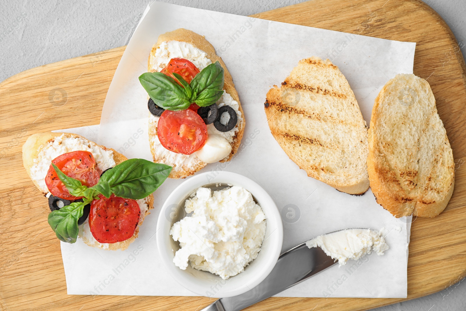 Photo of Delicious tomato bruschettas on wooden board, top view