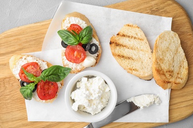 Photo of Delicious tomato bruschettas on wooden board, top view