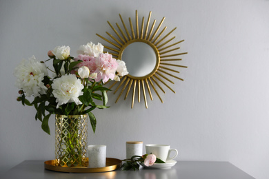 Photo of Bouquet of beautiful peony flowers on table indoors